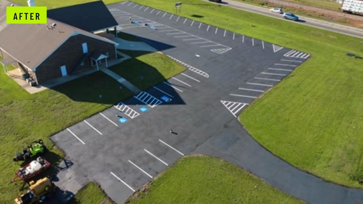 After: the same church lot resurfaced black with crisp white stalls, hatched aisles, directional arrows, and blue ADA stalls.