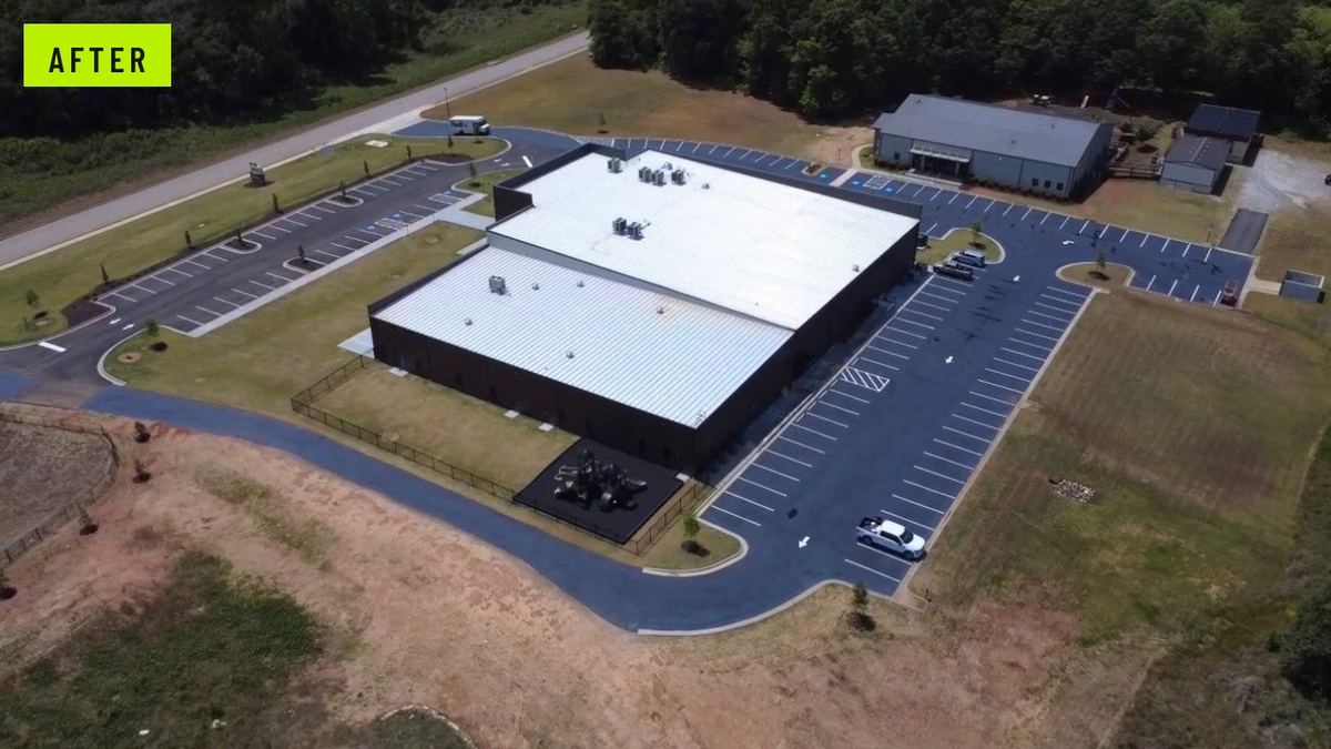 After: the same campus with a completed asphalt lot, paved perimeter drive, and full striping layout.